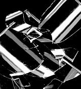 Broken shards of glass reflecting light scattered in a random heap on a black background in a close up view