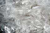 Abstract full frame background of transparent wrinkled plastic wrap with reflections of light and copy space
