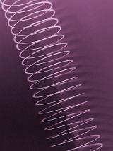 Fully extended light weight spring toy over purple background in diagonal composition