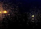 Pair of bright yellow and white exploding bursts or random ray of pixels over black background