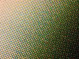 Extreme close up view on offset printing halftone matrix pattern in green, red and yellow gradient