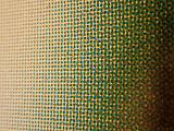 Close up on abstract pattern of green, black and red halftone dots over yellow background