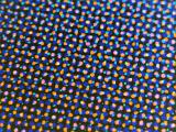 Colorful orange and blue dots scattered in rows over dark background with edges out of focus
