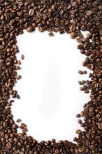 Border of aromatic medium roast coffee beans arranged around central white copy space for your text or advertising