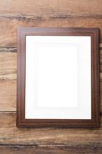 Blank empty simple wooden picture frame with an off white interior mount board and copy space on wood boards