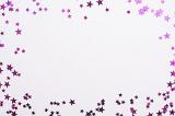 Colorful pink glitter star frame for Christmas, birthday or anniversary themed celebrations with center copy space on white for your greeting or advertising