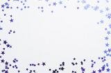 a frame of purple metallic stars of differing size with white background and space for text