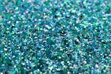 a background composed of flecks of green and cyan glitter