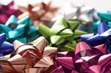 Background of colorful shiny decorative bows for gift wrapping ad packaging with focus to a pink and coppery one in the foreground