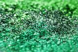 Extreme close up of green sparkling glitter with selective focus as a vivid abstract background