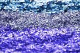 Abstract background texture of colorful sparkling blue glitter in three different shades with focus to the center band for use as a festive or craft background