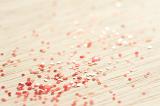 red coloured glitter particles scattered on a wooden background
