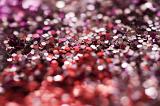 narrow depth of field image close-up on glitter sprinkles in purple and red colours