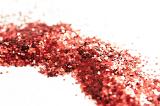 Trail of Red Glitter Across White Studio Surface - Abstract Background of Sparkling Red Glitter