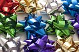 Colorful background of decorative bows in shiny ribbon for decorating gifts and packaging in assorted colors viewed from above