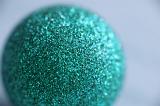 Close Up of Teal Glitter Ornament Ball Sparkling in Diffuse Selective Focus in Studio with Copy Space