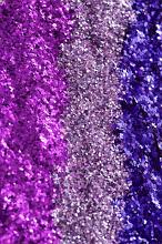 Festive glitter background texture with vertical bands of magenta, pink and blue glitter in a full frame view