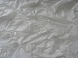 Crumpled dingy grey plastic sheeting background texture viewed from above in a full frame view