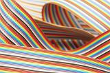 Colorful ribbon wires bent and curved in tangled manner for background about technology