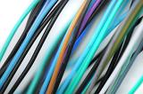 Colorful set of plastic coated wires in shades of blue, green, purple, black, white and grey diagonally across the frame