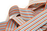 Pile of colorful striped computer ribbon wire in a tangled heap, close up isolated on white with copy space