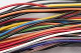 Close up on loose thick electrical wires in red, black, orange, yellow, blue, green and purple