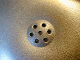 Macro close up on telephone earpiece section speaker with seven little holes in the middle