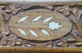 a carved wooden surface with shell inlay