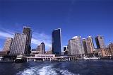 a view of tall buildings and the ferry terminal from the water at circular quay, sydeny