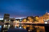 Night time view of Hobart Docks,Australia with the lights of the illuminated waterfront buildings reflected in the calm water, copyspace in the sky
