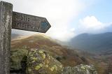 Wooden signpost with a pointer showing the route and direction for a Bridalway or footpath in scenic cloudy mountain scenery