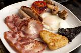Nothing says heartattack better than a Full English breakfast served on a plate with egg, bacon, sausage, hash browns, tomato and mushroom for a hearty start to the day