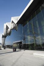 Exterior facade of the new Riverside Museum in Glasgow, Scotland, part of the Museum of Transport, with a tall ship in the harbour reflected in the large glass windows