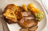 Traditional English roast beef dinner served with Yorkshire Pudding, vegetables and a rich gravy