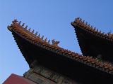 Architectural detail of the roof of a building or pagoda in the Forbidden City, Beijing, China against a clear blue sky in a travel concept