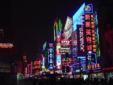 Commercial street in China with bright neon advertising lights covering the walls of the high rise buildings in a colorful night scene