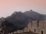 Tranquil Scenic of Historical Great Wall of China Through Fog Shrouded Mountains in Delicate Pink Lighting
