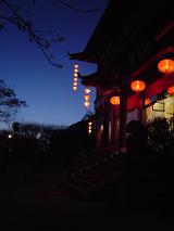Door to a traditional Chinese house lit by red lanterns shining in the darkness of the night in a welcoming scene