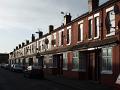 row of brick terraced houses in moss side, manchester, england