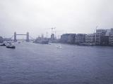 Overview of Boat Traffic and Building Development Along the River Thames with View of Tower Bridge in Background on Hazy Overcast Day in London, England