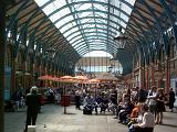 Interior of Covent Garden, London, once a fruit and produce market but now a shopping precinct with groups of shoppers under its arched glass roof