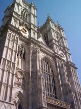 Facade of Westminster Abbey, Royal Peculiar and Gothic religious landmark from London, UK, shot from low angle, under a clear blue sky
