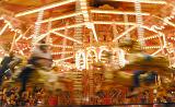 Motion blur view of the animals of a carousel or merry-go-round at an amusement park spinning past the lens
