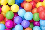 Background of a heap of colorful balls in rainbow colors in a full frame view from above