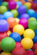 Colorful background of multicolored plastic balls in a ball pool with shallow dof in vertical format