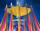 Acrobats performing during a live circus show on a colorful centre stage festooned with ribbons
