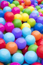 A close up of multicoloured plastic balls in a ball pit.