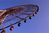 A low angle of a giant ferris wheel and clear, blue sky.