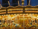 Illuminated colorful festive carousel at night at a funfair or amusement park with horses to ride in a close up view