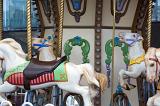 Colorful decorative horses on a carousel or merry-go-round at an amusement park in a close up view